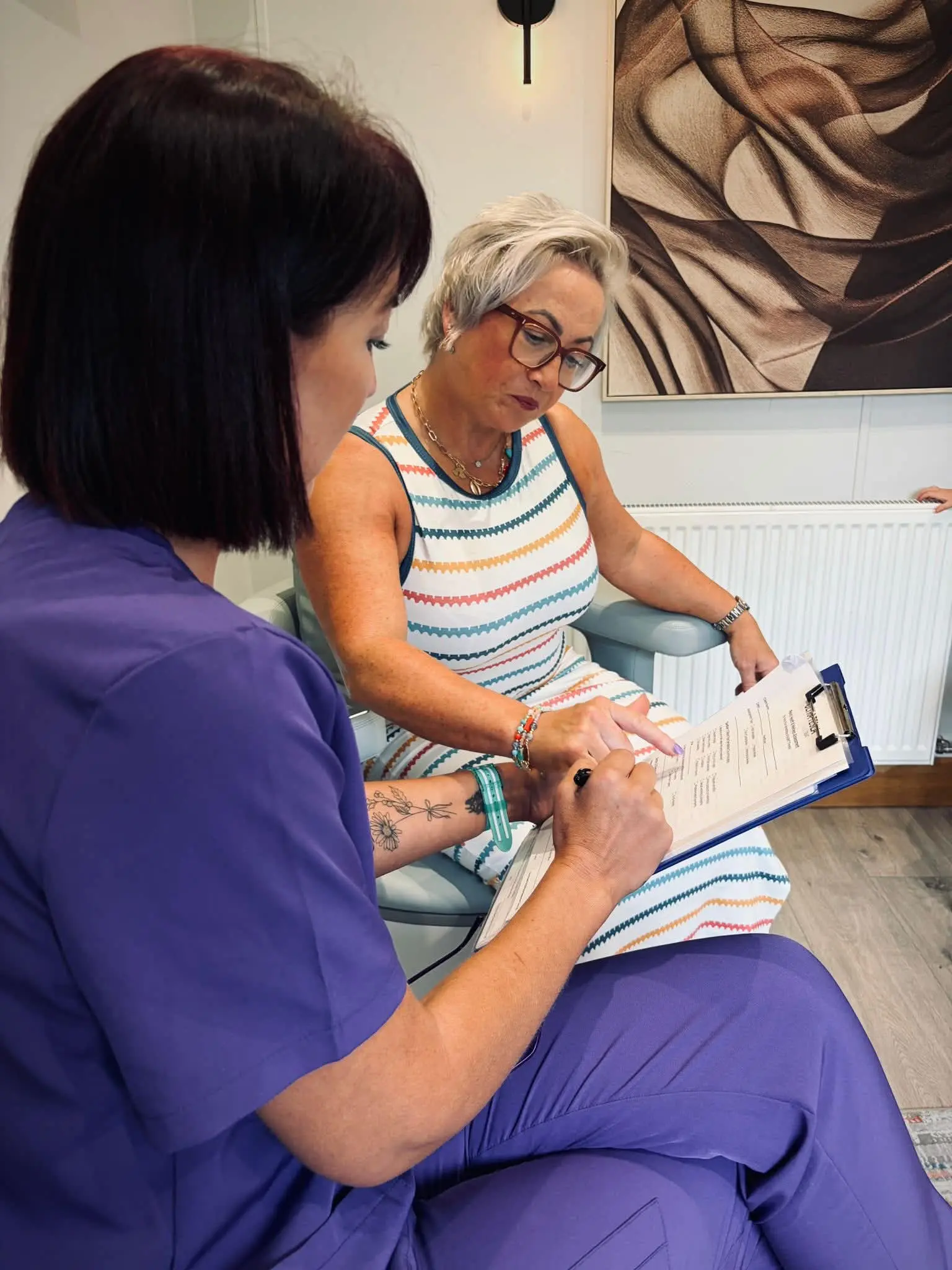 Jolene discussing a consultation form with a client